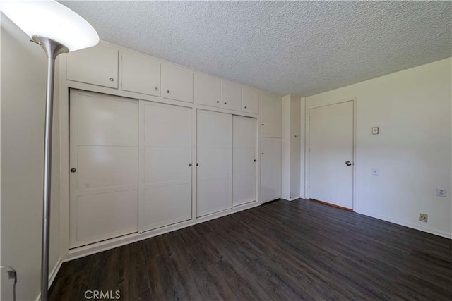 368 Avenida Castilla Unit B, Laguna Woods, CA 92637 - unfurnished bedroom with dark wood-type flooring, a closet, and a textured ceiling