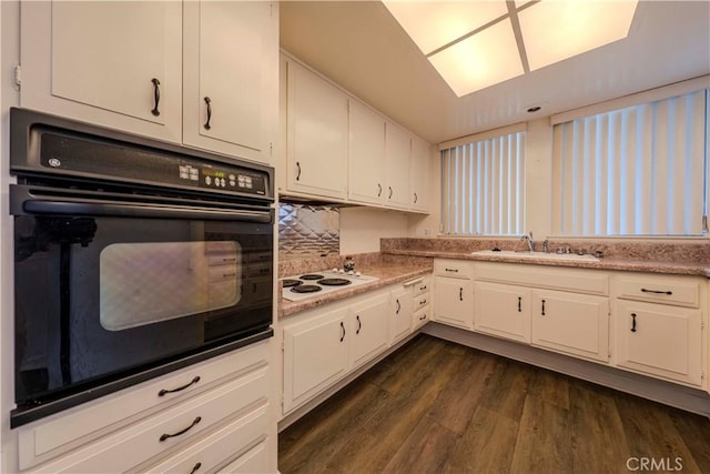 368 Avenida Castilla Unit B, Laguna Woods, CA 92637 - kitchen featuring black oven, white electric stovetop, dark wood finished floors, and white cabinetry