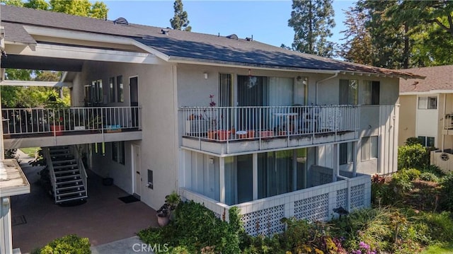 368 Avenida Castilla Unit B, Laguna Woods, CA 92637 - rear view of house featuring stairs, stucco siding, and a shingled roof