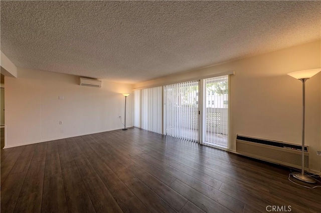 368 Avenida Castilla Unit B, Laguna Woods, CA 92637 - unfurnished room with a wall mounted AC, dark wood finished floors, and a textured ceiling