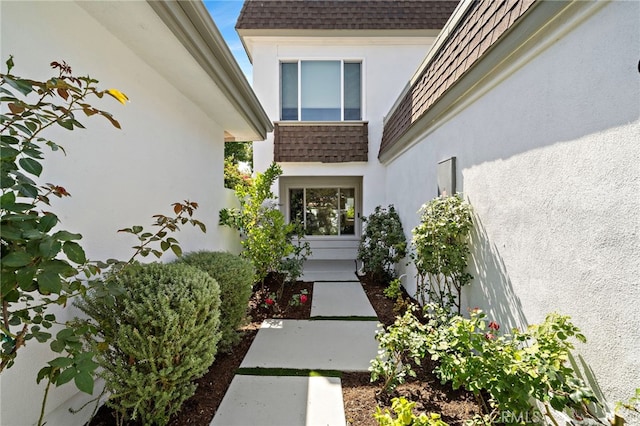 33 Seton Rd, Irvine, CA 92612 - view of exterior entry featuring roof with shingles, stucco siding, and mansard roof