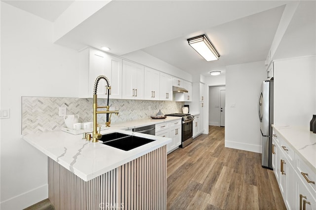 33 Seton Rd, Irvine, CA 92612 - kitchen featuring stainless steel appliances, decorative backsplash, wood finished floors, and a peninsula