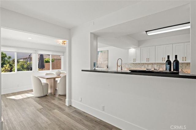 33 Seton Rd, Irvine, CA 92612 - kitchen featuring decorative backsplash, dark countertops, white cabinets, and light wood-type flooring
