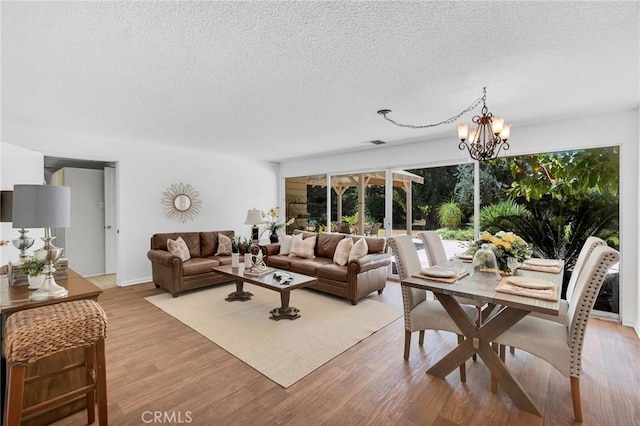 9700 Nita Ave, Chatsworth, CA 91311 - living room with a textured ceiling, a chandelier, healthy amount of natural light, and light wood-style flooring