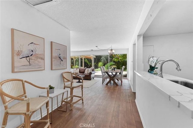 9700 Nita Ave, Chatsworth, CA 91311 - hallway featuring wood finished floors, a textured ceiling, and a chandelier