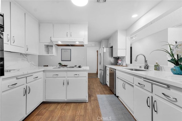 9700 Nita Ave, Chatsworth, CA 91311 - kitchen featuring under cabinet range hood, appliances with stainless steel finishes, wood finished floors, white cabinetry, and a peninsula