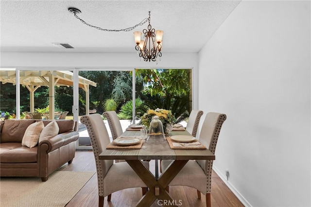 9700 Nita Ave, Chatsworth, CA 91311 - dining area featuring wood finished floors, a textured ceiling, and a chandelier