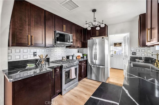 68613 E St, Cathedral City, CA 92234 - kitchen featuring stainless steel appliances, light wood-style flooring, backsplash, a chandelier, and dark brown cabinets