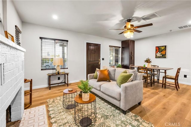 68613 E St, Cathedral City, CA 92234 - living room with a fireplace, a ceiling fan, light wood-style flooring, and recessed lighting