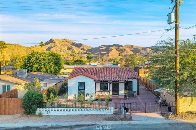 68613 E St, Cathedral City, CA 92234 - view of front of home featuring a tiled roof, a mountain view, a gate, a fenced front yard, and stucco siding