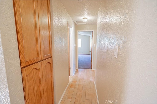 44623 Gingham Ave, Lancaster, CA 93535 - corridor featuring a textured wall, a textured ceiling, and light wood-style flooring