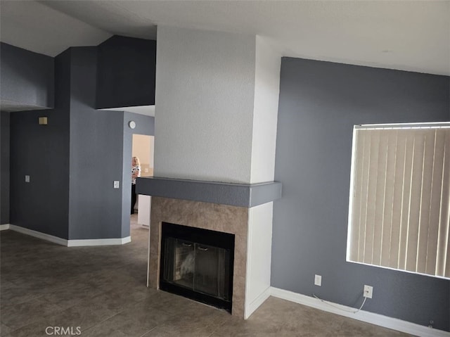 15171 San Jose Dr, Victorville, CA 92394 - unfurnished living room featuring a tiled fireplace and vaulted ceiling