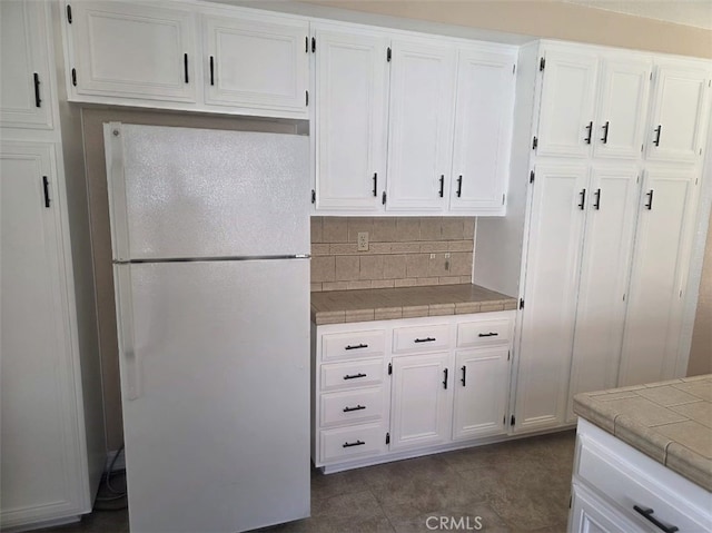 15171 San Jose Dr, Victorville, CA 92394 - kitchen with freestanding refrigerator, tile countertops, and white cabinets
