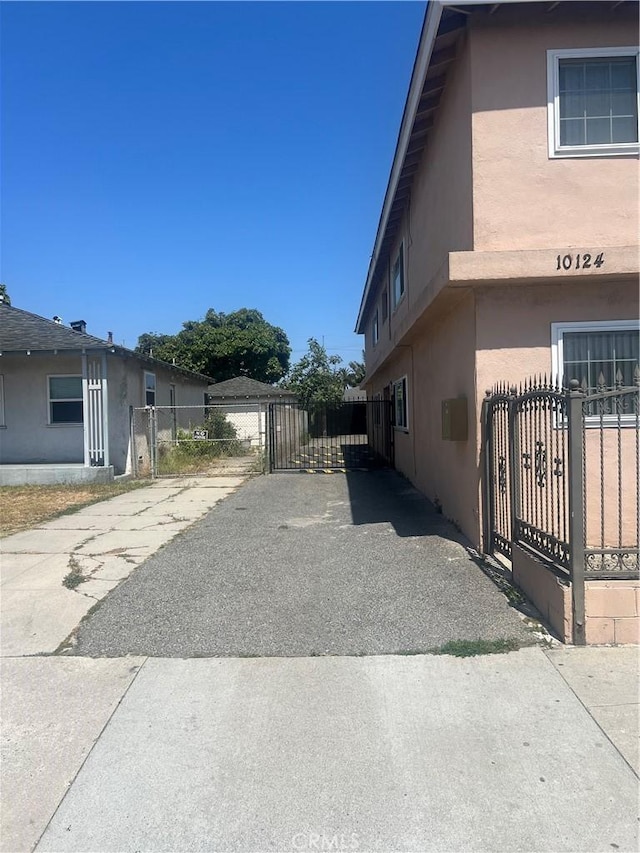 10124 S Inglewood Ave, Inglewood, CA 90304 - view of side of home featuring a gate, stucco siding, and driveway