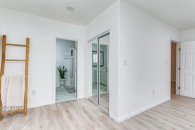 715 S Norton Ave, Los Angeles, CA 90005 - unfurnished bedroom with light wood-style flooring, a closet, and ensuite bath