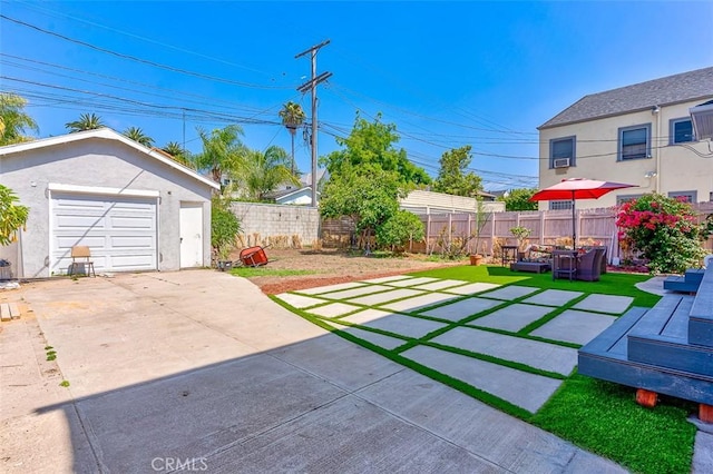 715 S Norton Ave, Los Angeles, CA 90005 - view of yard with an outdoor structure, a detached garage, concrete driveway, and a patio