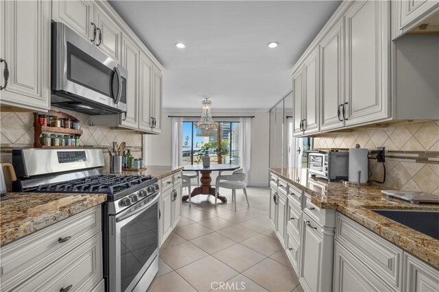 1215 Brockton Ave Unit 203, Los Angeles, CA 90025 - kitchen with stainless steel appliances, tasteful backsplash, light tile patterned flooring, recessed lighting, and light stone counters
