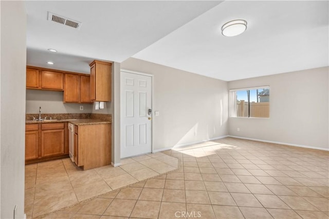 1339 Massachusetts Ave Unit 101, Riverside, CA 92507 - kitchen featuring brown cabinets, open floor plan, stone counters, and light tile patterned flooring