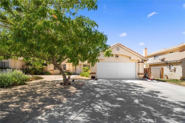 2908 Owens Way, Rosamond, CA 93560 - view of front of house featuring a garage, driveway, stucco siding, and a tiled roof