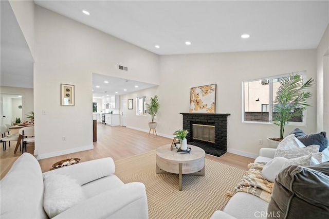 15604 Sharonhill Dr, Whittier, CA 90604 - living area with light wood finished floors, a brick fireplace, recessed lighting, and high vaulted ceiling