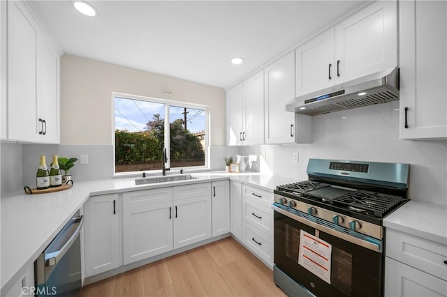15604 Sharonhill Dr, Whittier, CA 90604 - kitchen featuring appliances with stainless steel finishes, exhaust hood, backsplash, white cabinetry, and recessed lighting