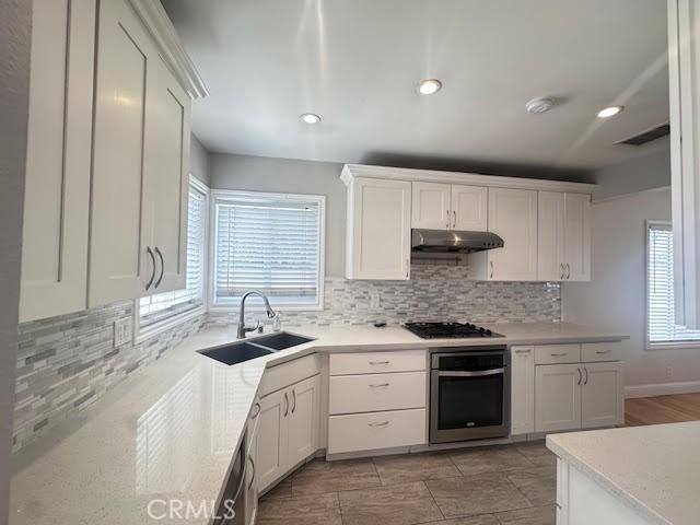 603 N Hawthorn St, Anaheim, CA 92805 - kitchen with stainless steel oven, under cabinet range hood, black gas cooktop, plenty of natural light, and recessed lighting