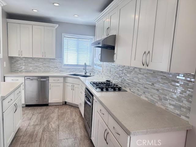 603 N Hawthorn St, Anaheim, CA 92805 - kitchen featuring appliances with stainless steel finishes, under cabinet range hood, light countertops, white cabinetry, and recessed lighting