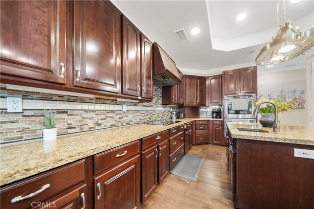 26677 Avenida Del Oro, Temecula, CA 92590 - kitchen featuring custom range hood, light wood-style flooring, light stone counters, double oven, and backsplash