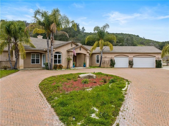 26677 Avenida Del Oro, Temecula, CA 92590 - single story home featuring curved driveway, stucco siding, a tiled roof, a chimney, and a garage