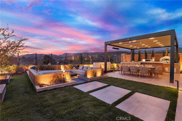 109 Ritual, Irvine, CA 92618 - yard at dusk with area for grilling, a patio area, exterior bar, a mountain view, and an outdoor living space with a fire pit