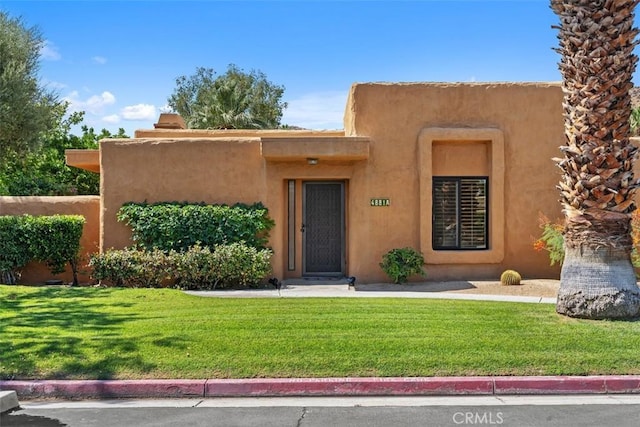 4881 S Winners Cir Unit A, Palm Springs, CA 92264 - pueblo revival-style home featuring a front lawn and stucco siding