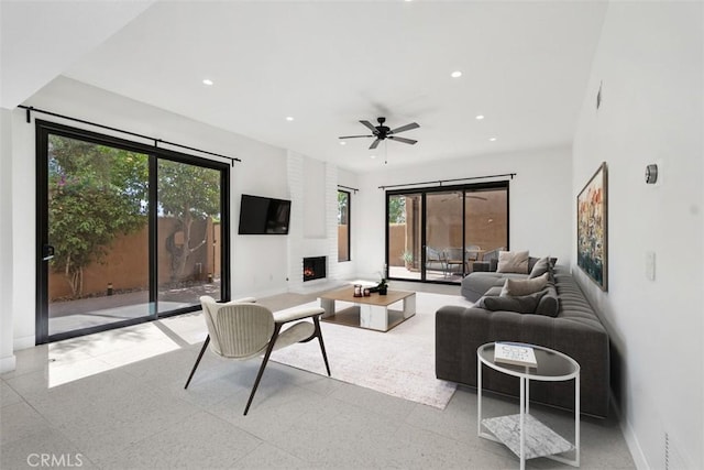 4881 S Winners Cir Unit A, Palm Springs, CA 92264 - living room with a large fireplace, a ceiling fan, and recessed lighting