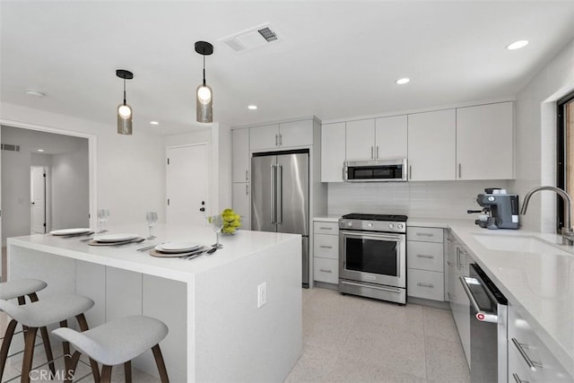 4881 S Winners Cir Unit A, Palm Springs, CA 92264 - kitchen featuring high quality appliances, a kitchen bar, recessed lighting, decorative light fixtures, and tasteful backsplash