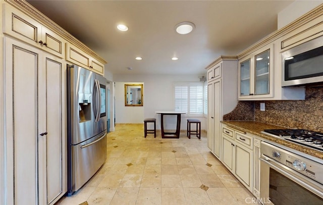 16671 Cedar Cir, Fountain Valley, CA 92708 - kitchen featuring cream cabinetry, stainless steel appliances, backsplash, glass insert cabinets, and recessed lighting