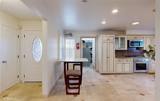 16671 Cedar Cir, Fountain Valley, CA 92708 - kitchen with appliances with stainless steel finishes, cream cabinets, backsplash, glass insert cabinets, and recessed lighting