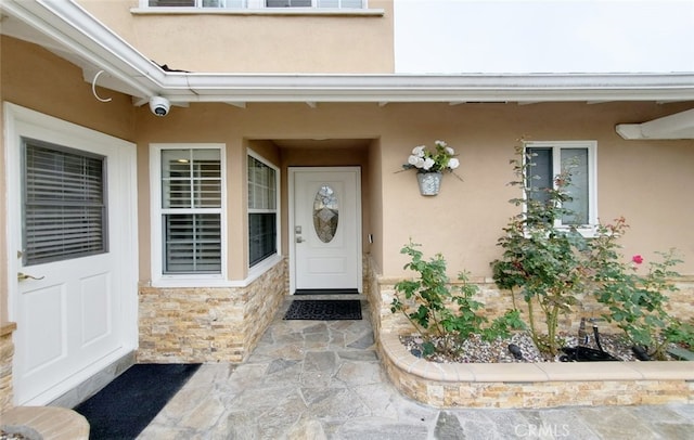 16671 Cedar Cir, Fountain Valley, CA 92708 - view of exterior entry with stucco siding, stone siding, and a surveillance system