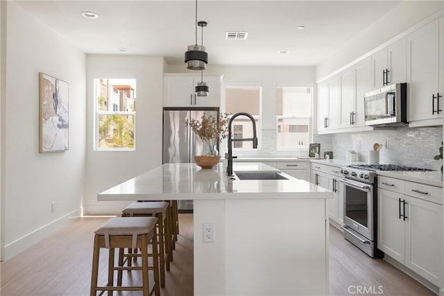 687 W 17th St, Costa Mesa, CA 92627 - kitchen featuring stainless steel appliances, plenty of natural light, a kitchen bar, backsplash, and recessed lighting