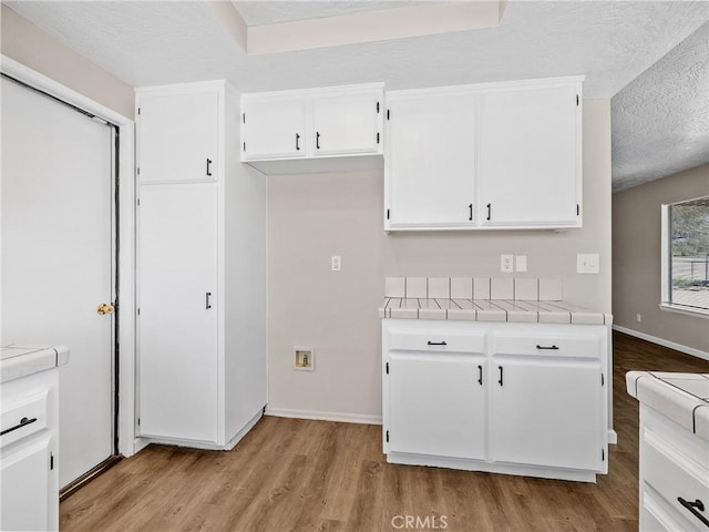 17702 Hinton St, Hesperia, CA 92345 - kitchen featuring tile countertops, light wood-type flooring, white cabinets, and a textured ceiling