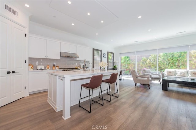 50 Tollson, Irvine, CA 92620 - kitchen with light wood-style floors, light countertops, white cabinetry, under cabinet range hood, and healthy amount of natural light