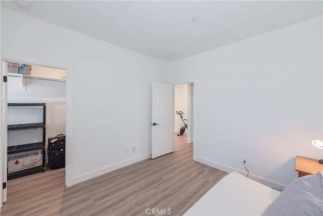 50 Tollson, Irvine, CA 92620 - bedroom with light wood-style flooring, a walk in closet, and a closet