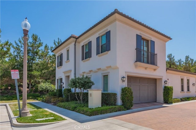 50 Tollson, Irvine, CA 92620 - view of front of home featuring a balcony, an attached garage, stucco siding, decorative driveway, and a tiled roof