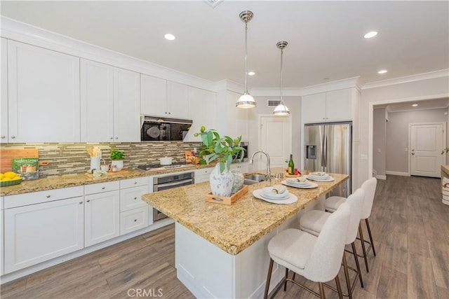 201 Bancroft, Irvine, CA 92620 - kitchen featuring stainless steel appliances, ornamental molding, white cabinetry, tasteful backsplash, and a kitchen bar