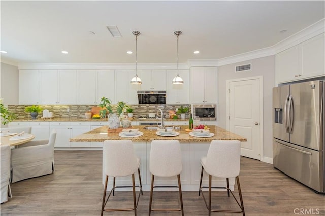 201 Bancroft, Irvine, CA 92620 - kitchen featuring stainless steel appliances, crown molding, white cabinetry, a breakfast bar area, and a center island with sink
