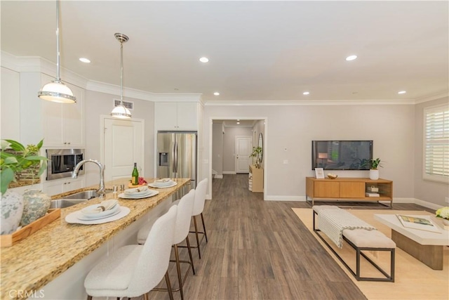 201 Bancroft, Irvine, CA 92620 - kitchen featuring a kitchen bar, stainless steel appliances, white cabinetry, pendant lighting, and recessed lighting