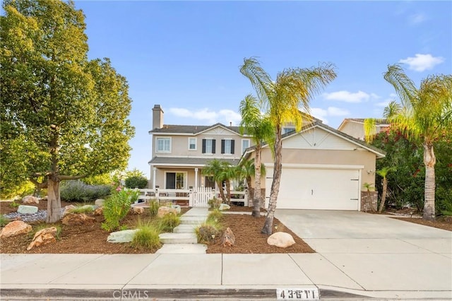 43611 Modena Dr, Temecula, CA 92592 - traditional home with driveway, a porch, an attached garage, stucco siding, and a chimney