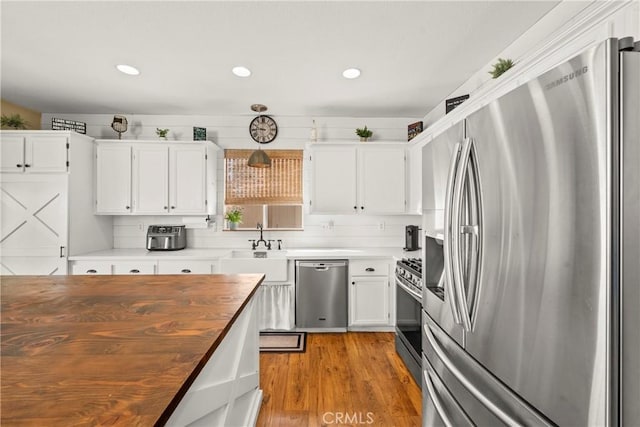 43611 Modena Dr, Temecula, CA 92592 - kitchen featuring stainless steel appliances, butcher block countertops, light wood-style flooring, white cabinets, and recessed lighting