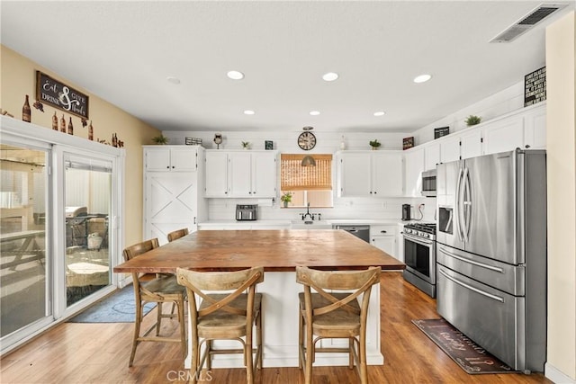 43611 Modena Dr, Temecula, CA 92592 - kitchen featuring stainless steel appliances, white cabinets, light wood-style flooring, and recessed lighting