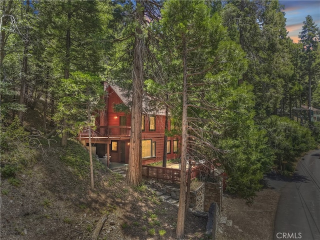 425 Blue Jay Canyon Rd, Blue Jay, CA 92317 - property exterior at dusk featuring a wooden deck and a wooded view