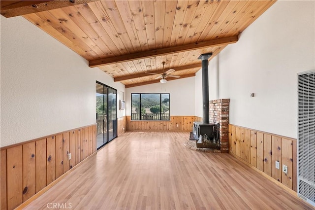 14526 Hardtree Dr, Lake Hughes, CA 93532 - unfurnished living room with wooden walls, a wainscoted wall, a heating unit, wood finished floors, and a wood stove