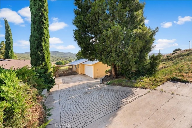 14526 Hardtree Dr, Lake Hughes, CA 93532 - view of front of house featuring a carport, a mountain view, driveway, and stucco siding